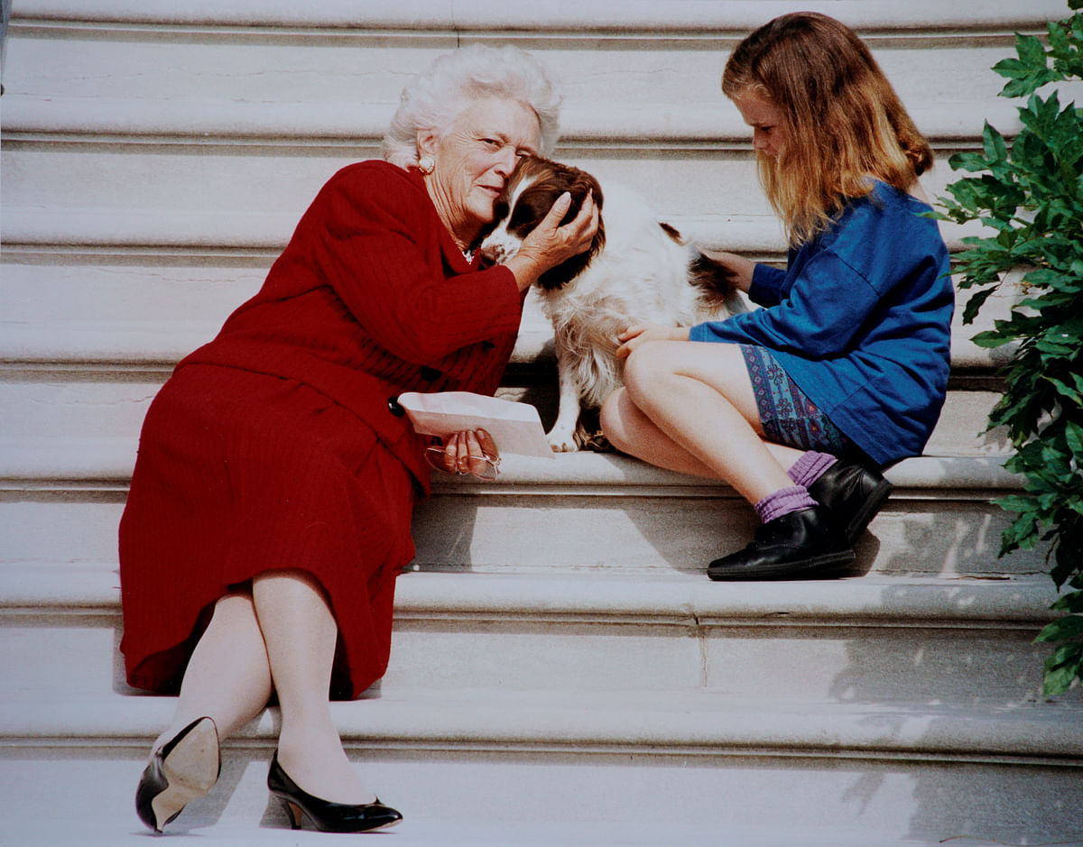 Barbara Bush pets her dog Millie while waiting with her grandaughter Barbara for president George H.W. Bush to arrive on White House steps in Washington. Reuters