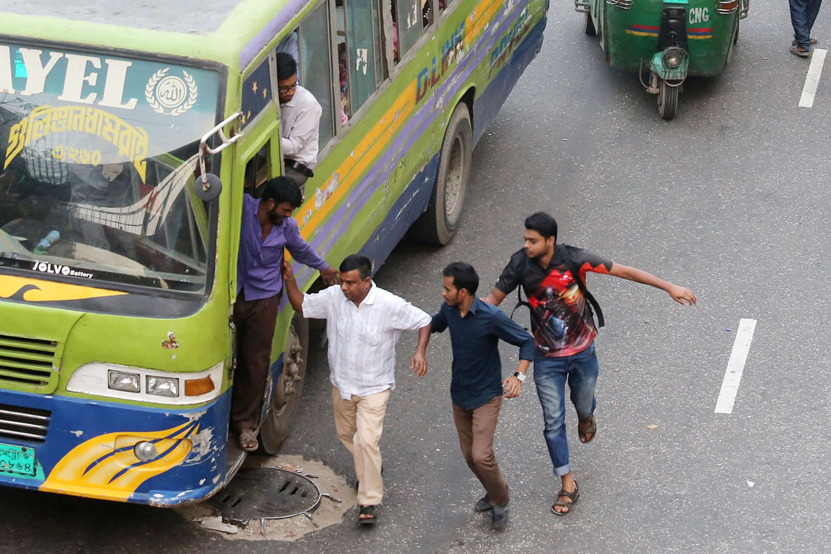 Passengers rush to catch a moving bus. Photo: Zahidul Karim