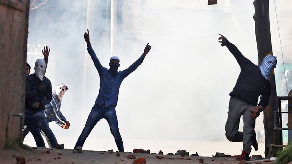 A protester throws rubble at Indian Police during a protest against the recent killings in Kashmir, in Srinagar April 13, 2018. Photo : Reuters
