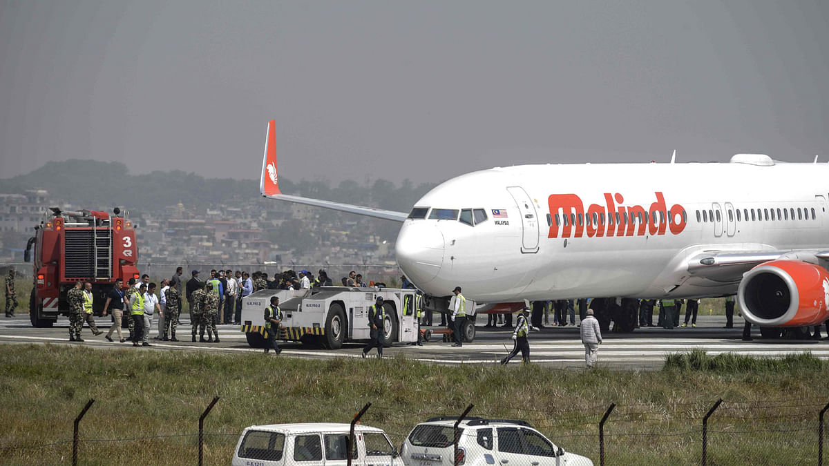 Nepali workers try to bring a Malaysian airliner back onto the runway at the international airport in Kathmandu on 19 April 2018, after it skidded off the runway following an aborted take-off. Kathmandu airport was closed 20 April after a Malaysian jet with 139 people on board aborted its takeoff and skidded off the runway. Photo: AFP