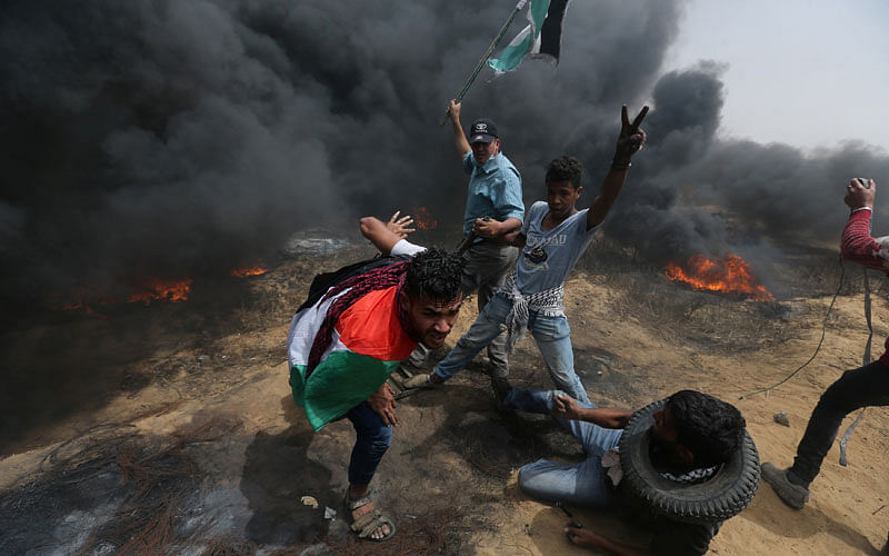 Demonstrators take cover during clashes with Israeli troops at a protest where Palestinians demand the right to return to their homeland, at the Israel-Gaza border in the southern Gaza Strip on 20 April. Photo: Reuters