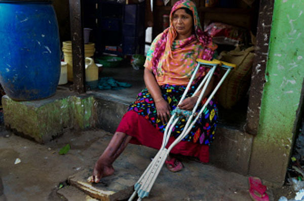 In this photograph taken on April 17, 2018 Nilufer Begum, an injured garment worker who survived the Rana Plaza disaster, sits with her crutches by her small tea stall in Savar, northwest of the Bangladeshi capital Dhaka.