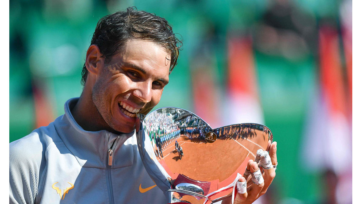 Spain`s Rafael Nadal holds the trophy as he celebrates his win over Japan`s Kei Nishikori in their final match at the Monte-Carlo ATP Masters Series tournament on 22 April 2018, in Monaco. AFP