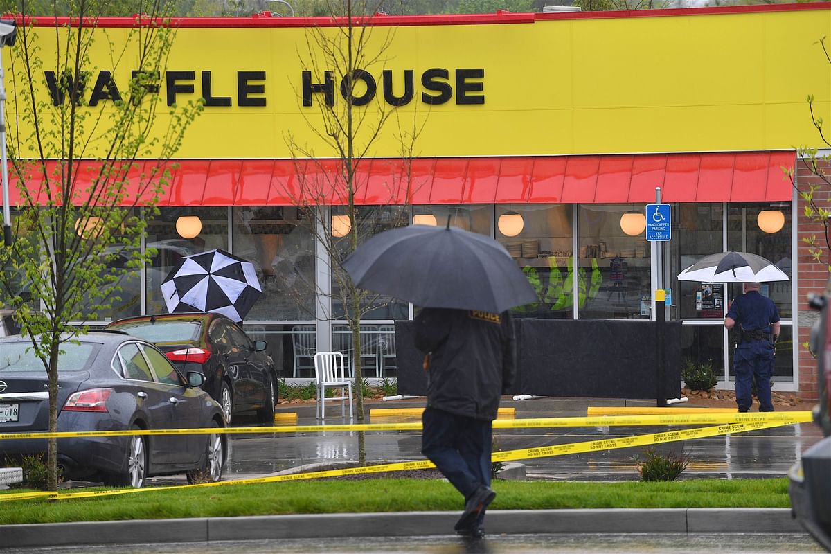Law enforcement stand outside a Waffle House where four people were killed and two were wounded after a gunman opened fire with an assault weapon on Sunday. Photo: AFP