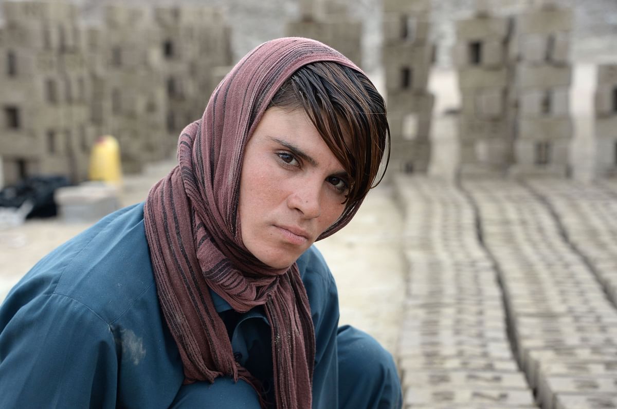 This photograph taken on 11 March, 2018 shows Afghan female labourer Sitara Wafadar, 18, who dresses as a male in order to support her family, posing for a picture at a brick factory in Sultanpur village in Surkh Rod district, in Afghanistan`s eastern Nangarhar province. Photo: AFP
