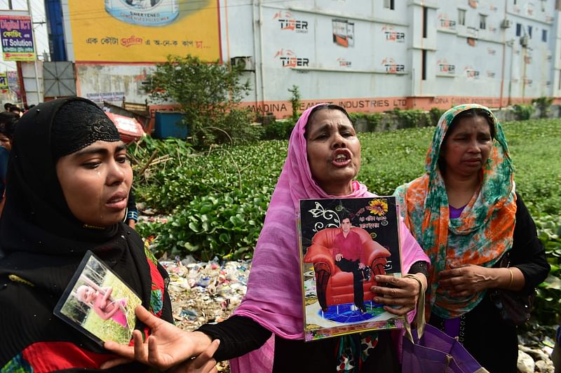 A relative (C) of a victim killed in the Rana Plaza building collapse reacts as she and others mark the fifth anniversary of the disaster at the site where the building once stood in Savar, on the outskirts of Dhaka, on 24 April 2018. AFP