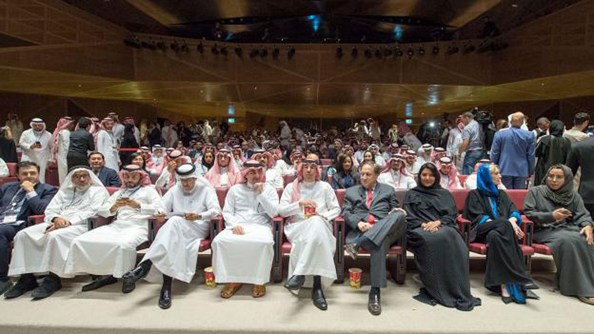 A handout picture provided by the Saudi Royal Palace on 18 April, 2018, shows Saudi information minister Awwad Alawwad (C) holding a small bucket of popcorn as he attends a test screening at the AMC cinema in the capital Riyadh, the first test in over three decades. Photo: AFP