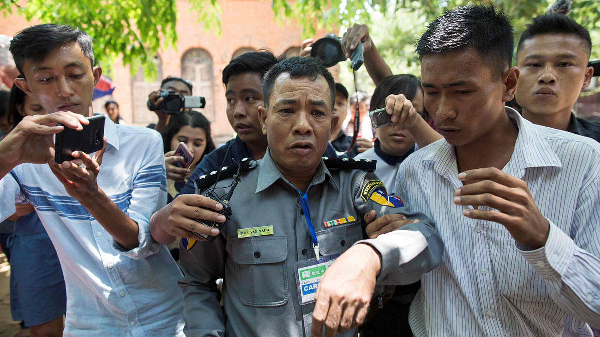In this file photo taken on 20 April, 2018 Myanmar deputy police major Moe Yan Naing (C) leaves the court following the ongoing trial of two detained journalists in Yangon. Photo: AFP