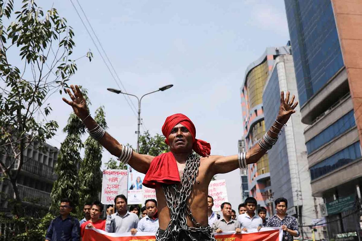 A man wears a metal chain as he participates in a May Day rally in Dhaka, Bangladesh, 1 May. Photo: Reuters