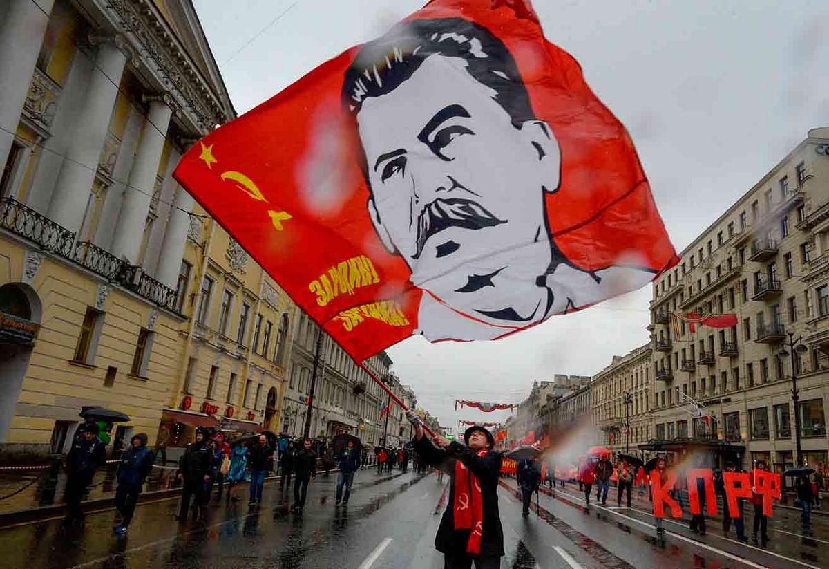 A Russian Communist party supporter waves a red flag with an image of Soviet leader Joseph Stalin during a May Day rally in Saint Petersburg on 1 May, 2018. Photo: AFP