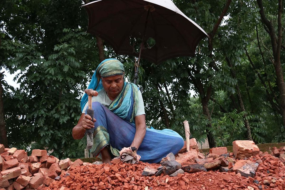 An elderly woman uses hammer to break bricks in Faridpur`s Sadar upazila on 30 April. Photo: Alimuzzaman