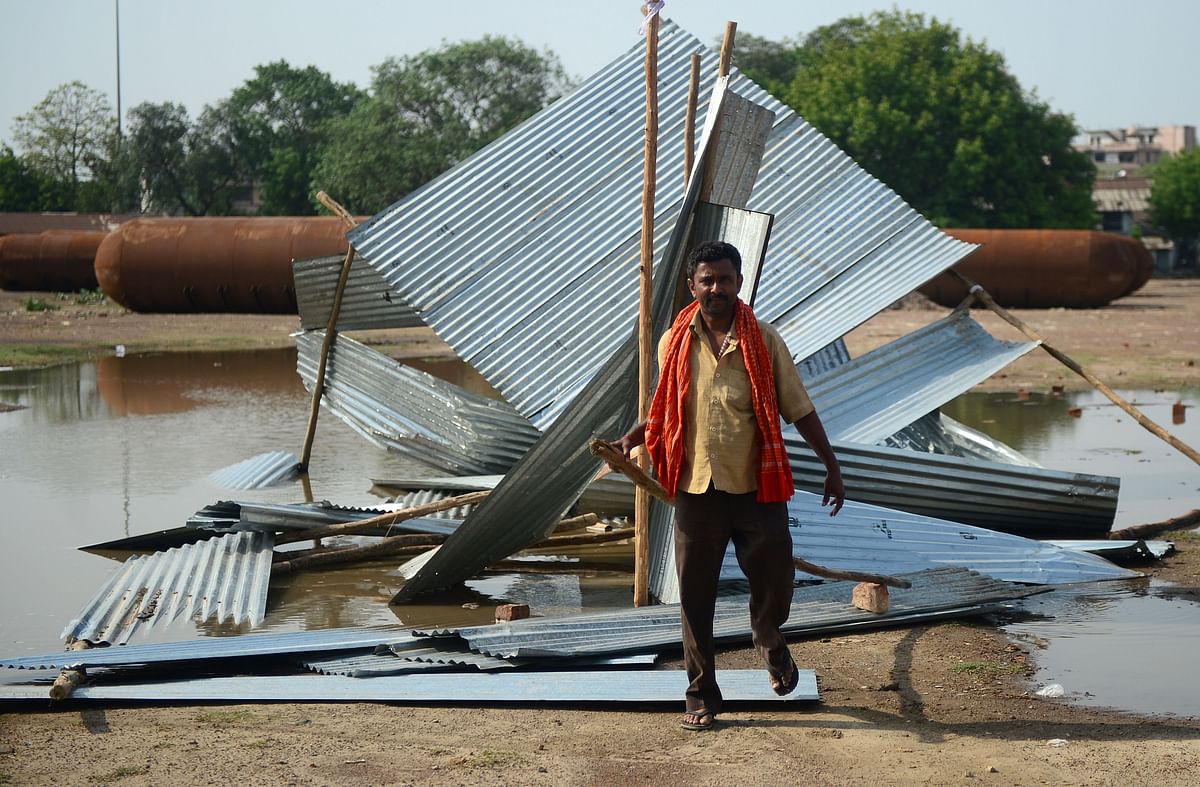 An Indian man passes next to a destroyed tin shed near a construction site following a major storm in Allahabad on 3 May, 2018. Photo: AFP