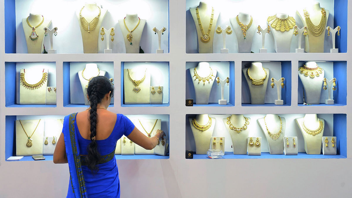 In this file photo taken on 11 August, 2017 an employee of an Indian jewellery store arranges gold jewellery in a display at a stall in the Asia Jewels Fair 2017, in Bangalore. Photo: AFP