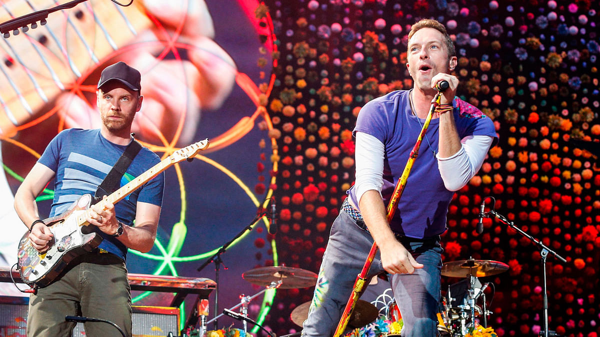 In this file photo taken on 15 July, 2017 Lead singer of British band Coldplay Chris Martin (R) with guitarist Jonny Buckland perform at The Stade de France Arena in Saint Denis on the outskirts of Paris. Photo: AFP