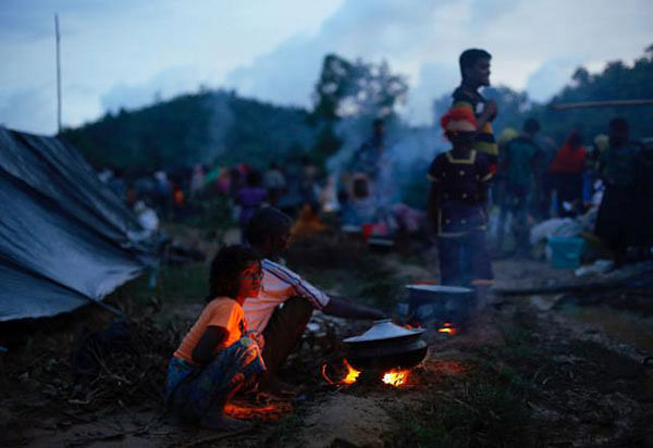 Rohingya refugees cook food outside their temporary shelters at Thaingkhali makeshift refugee camp in Cox`s Bazar, Bangladesh, 14 September, 2017. Photo: Reuters