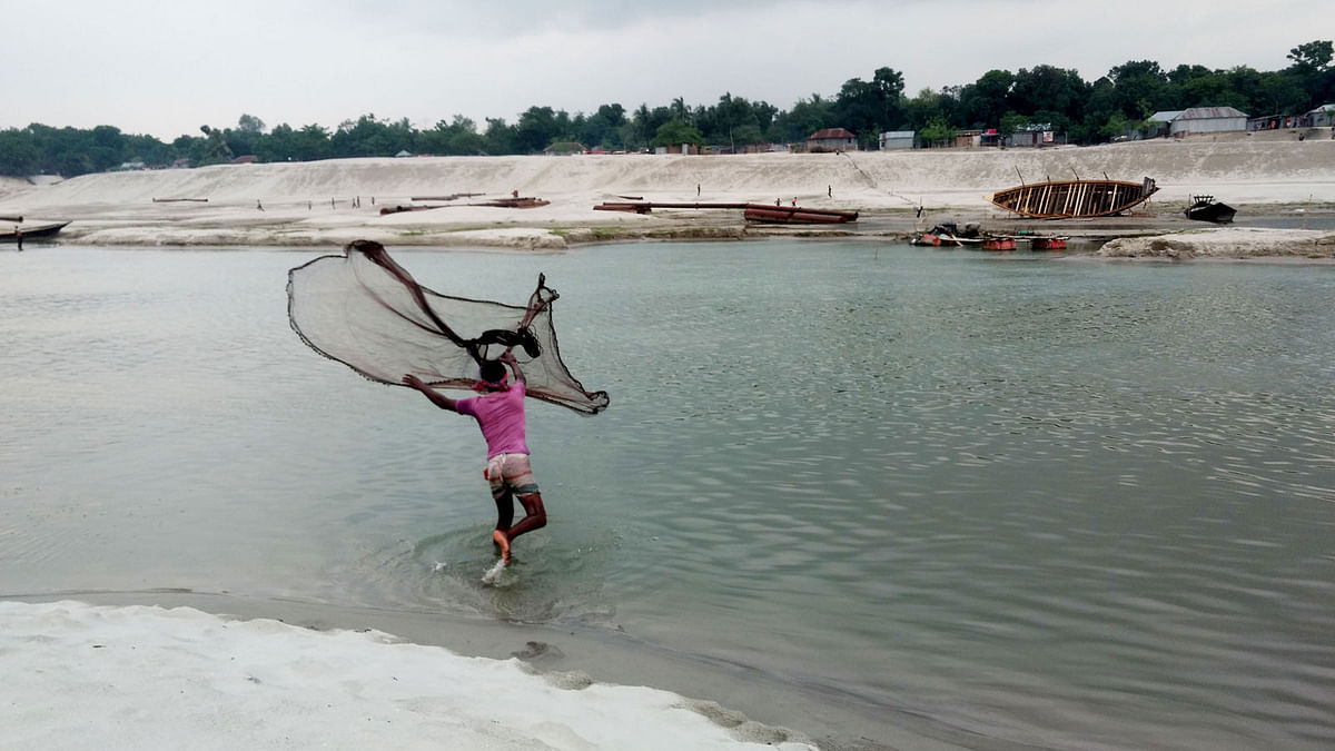 A man throws fishing net in Gorai river inThanapara in Kushtia on 5 May. Photo: Touhidi Hasan