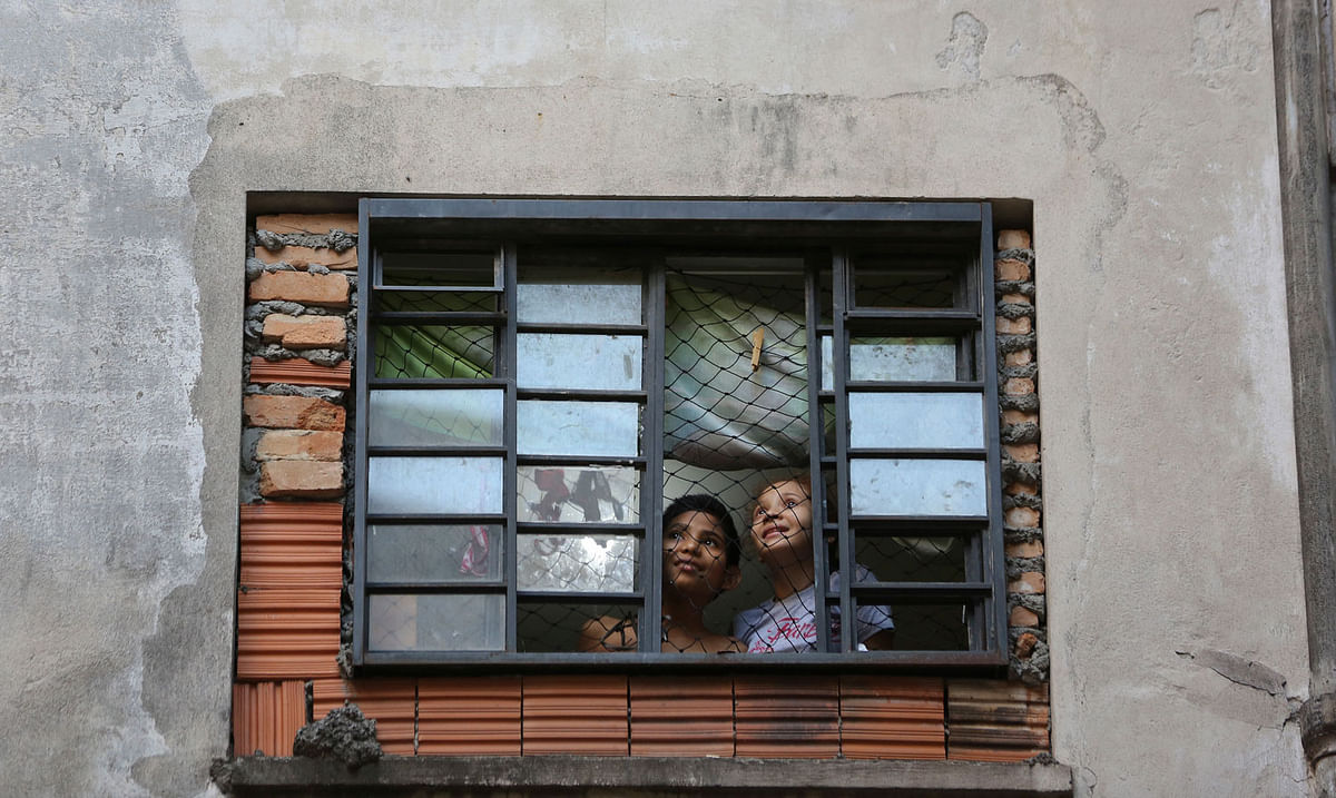 Children residents look from their window at the Maua building, which is occupied by squatters in downtown Sao Paulo, Brazil on 4 May. Photo: AP