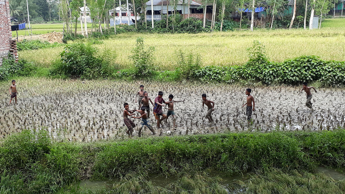 Boys play football in a watery rice field after the harvest in Lakshmikhola of Raiganj upazila in Sirajganj on 7 May. Photo: Sajedul Islam