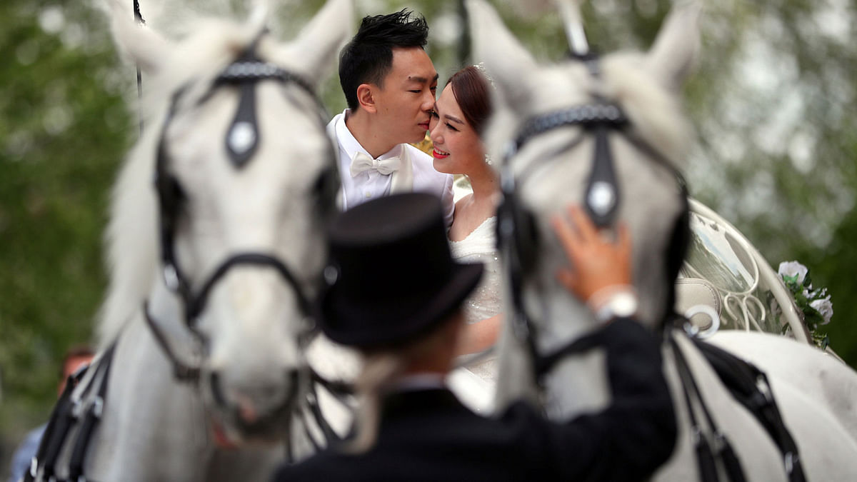 People dressed in wedding attire pose for photographs in central London, Britain on 8 May. Photo: Reuters