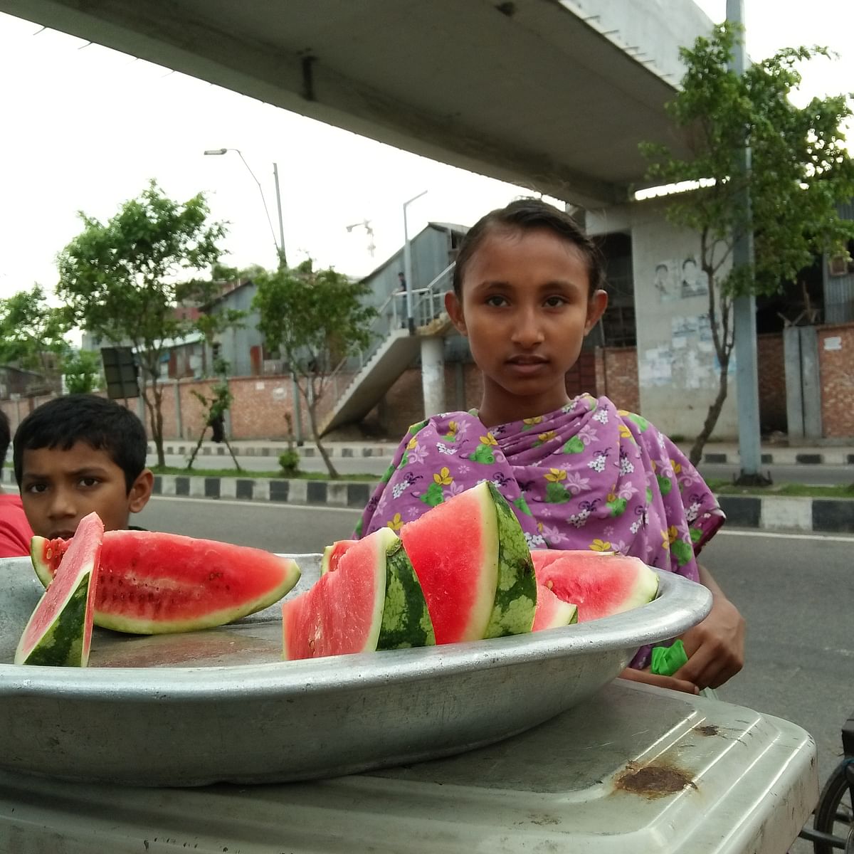 The underprivileged children sell watermelon slices and also play in Hatirjheel, Dhaka. A recently taken photo by Nusrat Nowrin