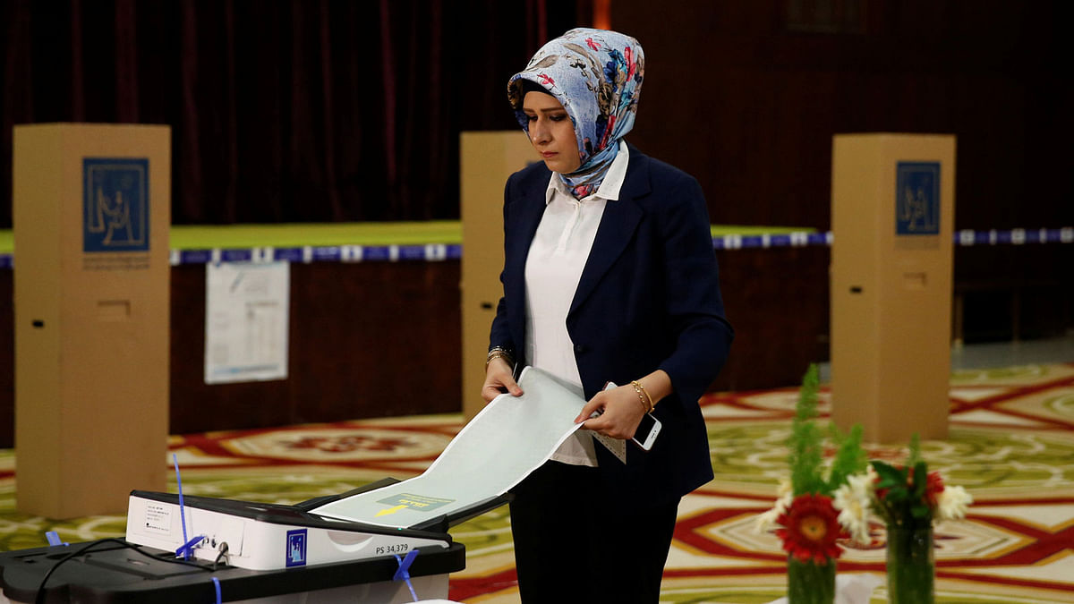An employee from Iraq`s Independent High Electoral Commission casts her vote at a polling station during the parliamentary election in Baghdad, Iraq on 12 May 2018. Reuters