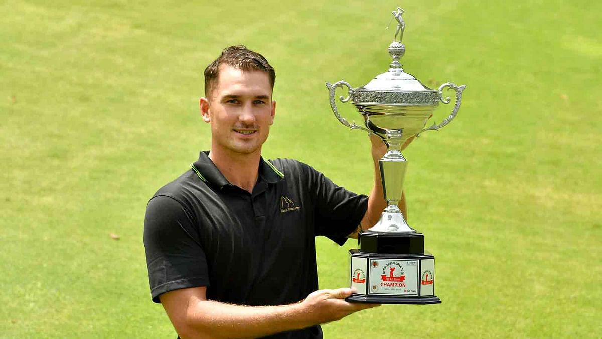 This handout photo taken and released on 11 May, 2018, by the Asian Tour shows Malcolm Kokocinski of Sweden with the winner`s trophy after round four of the Bangladesh Open golf tournament at the Kurmitola Golf Club in Dhaka. Photo: AFP
