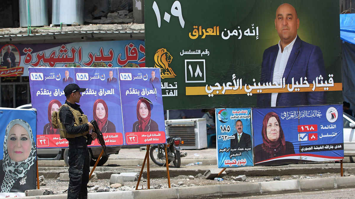 An Iraqi policeman guards a checkpoint by electoral posters in the old town of Mosul on 11 May, 2018, as Iraq prepares for the parliamentary elections to be held on 12 May. Photo: AFP