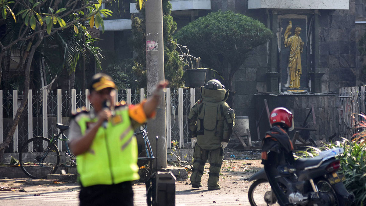 A member of the police bomb squad unit examines the site of an explosion outside the Immaculate Santa Maria Catholic Church, in Surabaya, East Java, Indonesia on 13 May 2018. Photo: Reuters