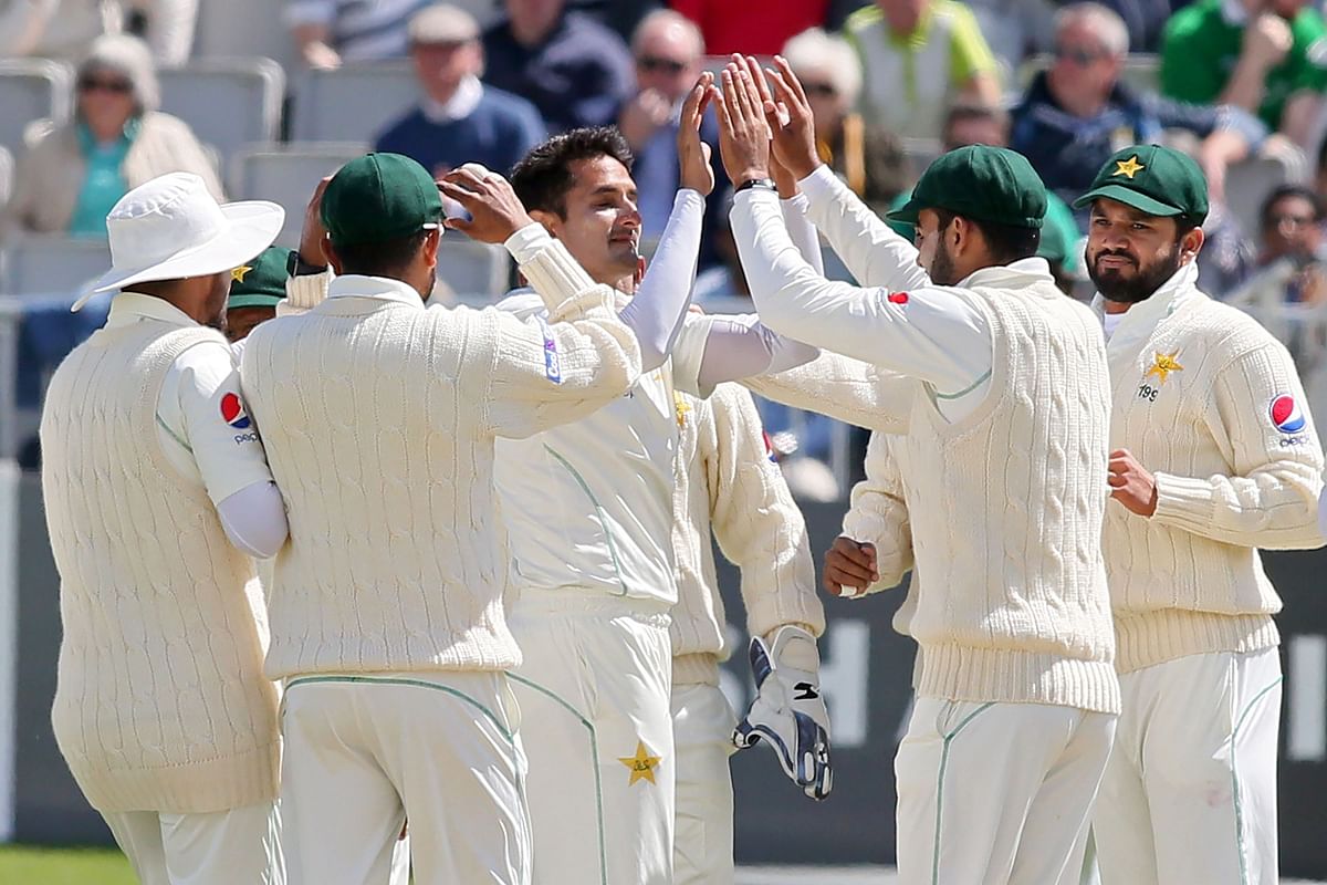 Pakistan`s Mohammad Abbas (C) celebrates with teammates after trapping Ireland`s Ed Joyce leg before wicket (LBW) during play on day three of Ireland`s inaugural test match against Pakistan at Malahide cricket club, in Dublin on 13 May, 2018. Photo: AFP