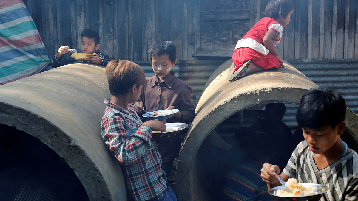 Children receive food in a shelter for internally displaced people in Myitkyina while Myanmar’s military still fighting Kachin Independence Army (KIA) in the country’s northern Kachin State, Myanmar on 10 May. Photo: Reuters