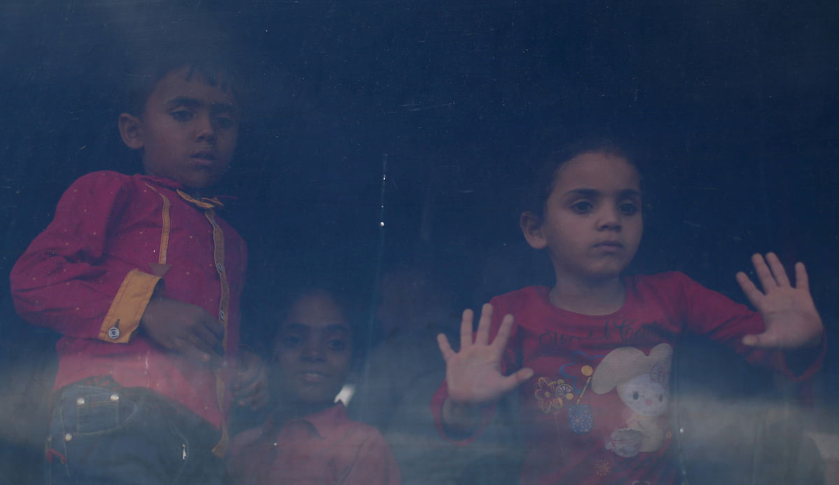 Children look through a bus window as they wait to travel into Egypt through Rafah border crossing after it was opened by Egyptian authorities for humanitarian cases, in the southern Gaza Strip on 13 May 2018. Reuters