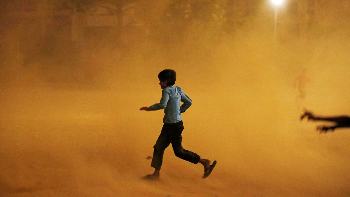 A boy runs for cover during a dust storm in New Delhi, India on 13 May 2018. Reuters