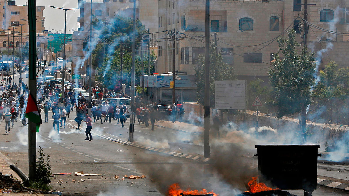 Palestinians throw stones towards Israeli security forces during clashes after a protest marking the 70th anniversary of Nakba -- also known as Day of the Catastrophe in 1948 -- and against the US` relocation of its embassy from Tel Aviv to Jerusalem, at the main entrance of the occupied West Bank city of Bethlehem on 15 May, 2018. Photo: AFP