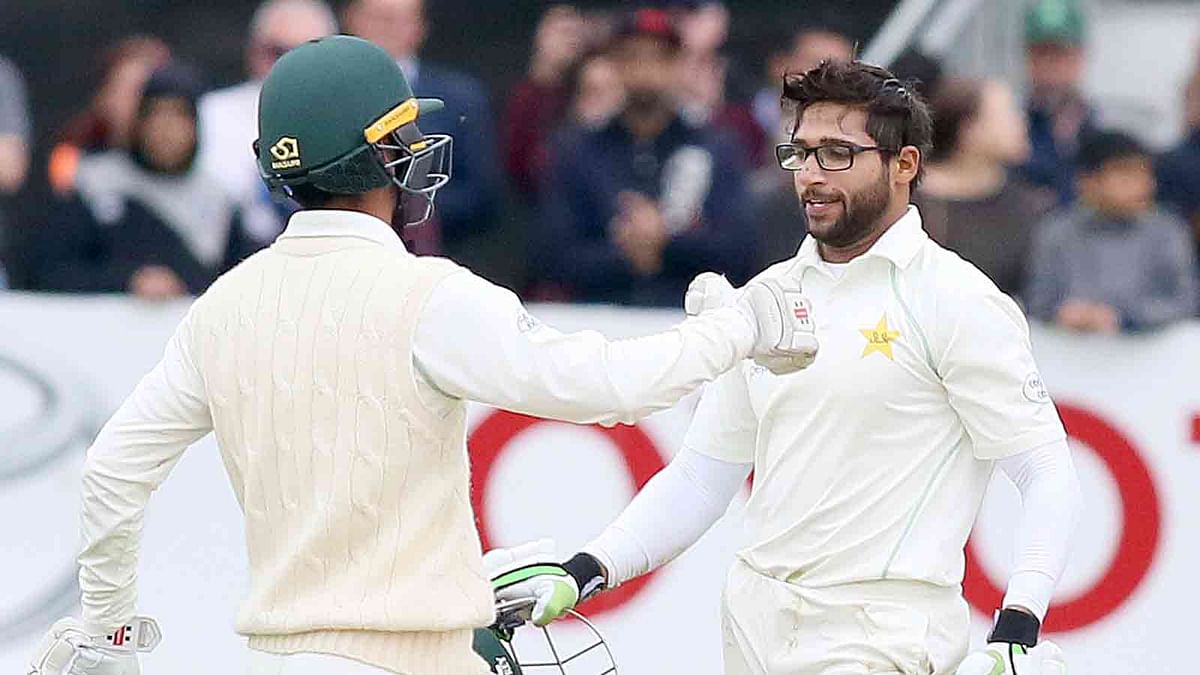 Pakistan`s Imam-ul-Haq (R) and Khan Shadab celebrate after beating Ireland on the final day of Ireland`s inaugural test match against Pakistan at Malahide cricket club, in Dublin on 15 May, 2018. Photo: AFP