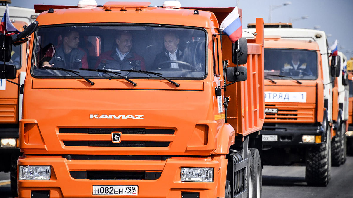 Russian president Vladimir Putin (R, front) drives a Kamaz truck during a ceremony opening a bridge, which was constructed to connect the Russian mainland with the Crimean Peninsula across the Kerch Strait, on 15 May 2018. Photo: Reuters