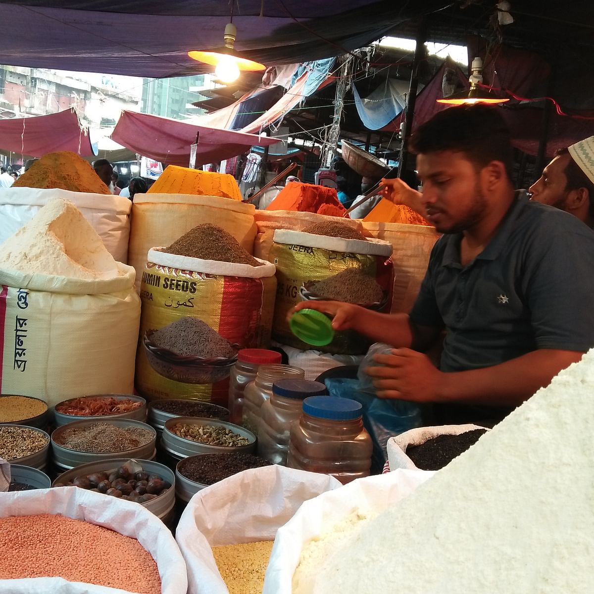 Abdur Rahim, a seller at the Karwan Bazar kitchen market, busy selling spices. Photo: Nusrat Nowrin