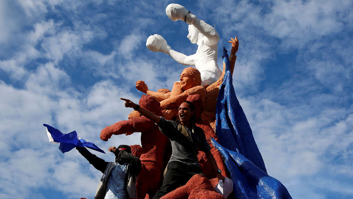 Demonstrators stand on a monument of three-time world boxing champion Alexis Arguello during a demonstration against President Daniel Ortega’s government in Managua, Nicaragua on 18 May. Photo: Reuters