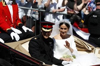 Britain's Prince Harry, Duke of Sussex and his wife Meghan, Duchess of Sussex wave from the Ascot Landau Carriage during their carriage procession on the High Street in Windsor, on 19 May 2018 after their wedding ceremony.  Photo: AFP