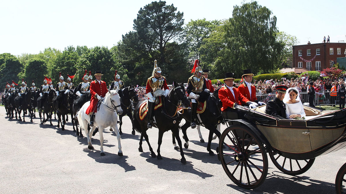 Britain`s Prince Harry and his wife Meghan Markle ride a horse-drawn carriage, after their wedding ceremony at St George`s Chapel in Windsor, Britain, 19 May, 2018. Photo: Reuters