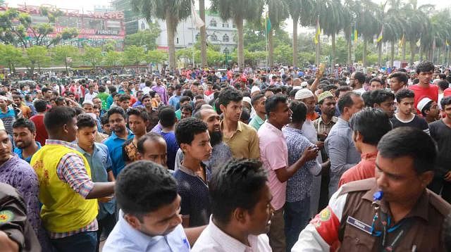 Mobile phone shop owners and their salespersons blockade Panthapath road in front of Bashundhara City shopping mall on Saturday afternoon. Photo: Shuvra Kanti das