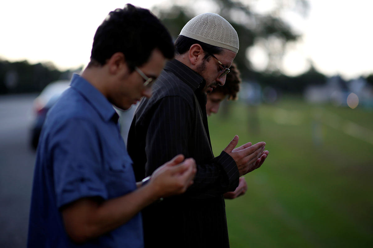 Daniel Hernandez, a local imam, prays with his two sons near the site of the shooting at the Santa Fe High School, in Santa Fe, Texas, US, 19 May 2018. Photo: Reuters