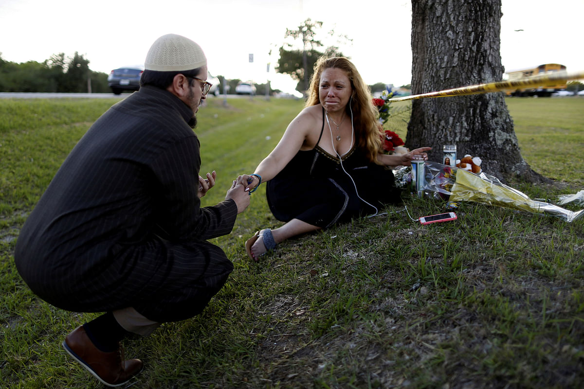 Daniel Hernandez, a local imam, comforts Dih-Anaa Forero of Missouri City, near the site of the shooting at the Santa Fe High School, in Santa Fe, Texas, US, 19 May 2018. Photo: Reuters