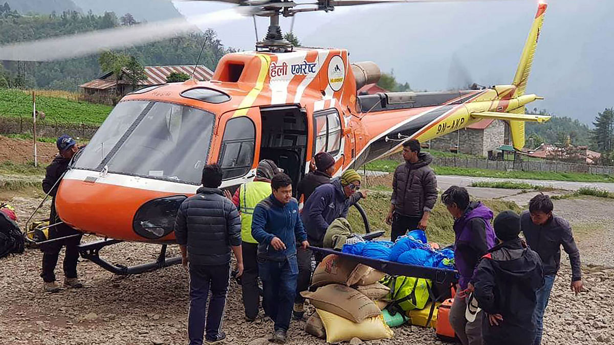 Nepali men carry the body of Japanese climber Nobukazu Kuriki onto a helicopter after it was recovered from Mount Everest, at a helipad in Lukla to be airlifted to Kathmandu on 21 May, 2018. Photo: AFP
