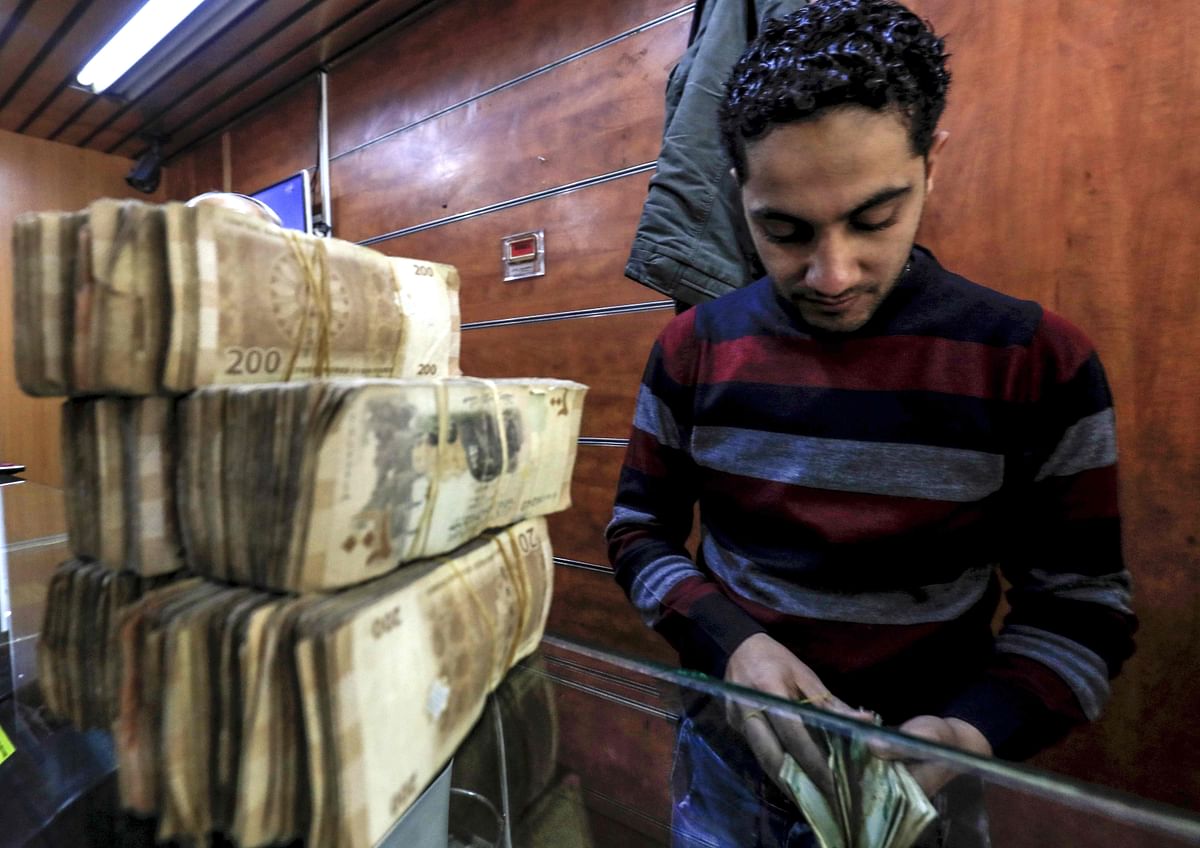 An employee of a currency exchange counter counts banknotes at a market street in the northeastern Syrian town of Qamishli on 2 May 2018. Photo: AFP