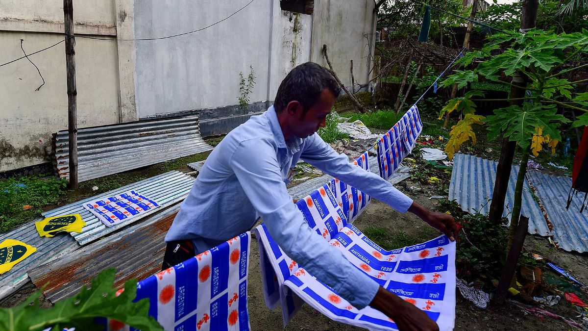 This photograph taken on 17 May 2018, shows Salim Hawalader, owner of a factory that produces national flags, hanging Argentine flags in Narayanganj, on the outskirts of Dhaka, ahead of the 2018 football World Cup. Photo: AFP