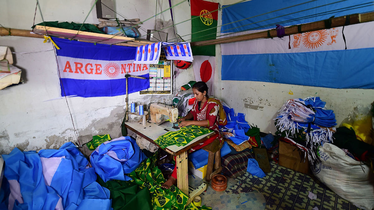 This photograph taken on 17 May 2018 shows a Bangladeshi worker sewing flags for world cup football playing nations in Narayanganj, on the outskirts of Dhaka, ahead of the 2018 football World Cup. Photo: AFP