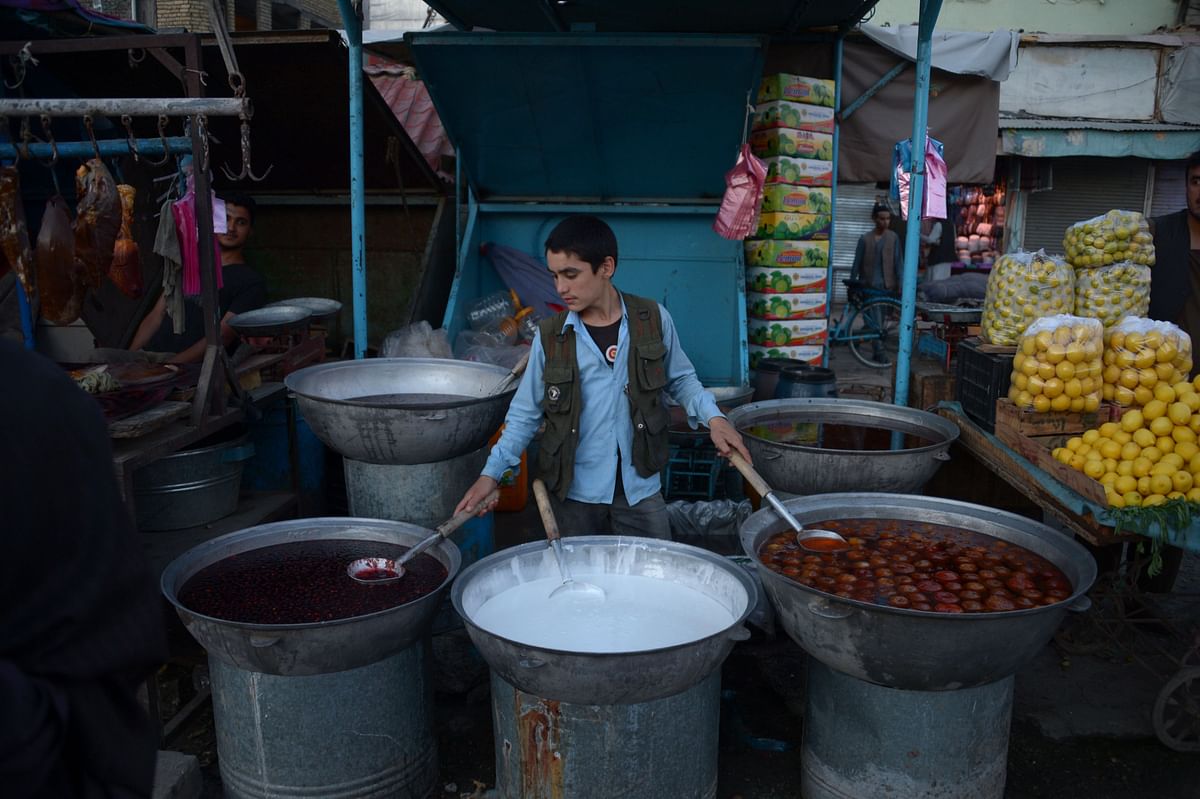 In this photograph taken on 21 May 2018, An Afghan boy sells homemade snacks from his stall during the Islamic holy month of Ramadan in Mazari-i-Sharif. Muslims throughout the world are marking the month of Ramadan, the holiest month in the Islamic calendar during which devotees fast from dawn till dusk. Photo: AFP