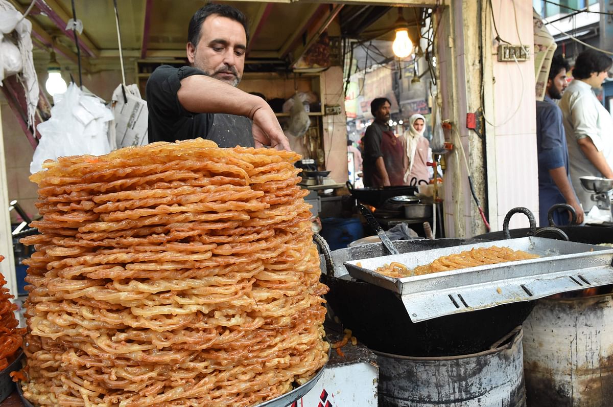 A Pakistani baker arranges sweet Jalebi for Muslim devotees before breaking the fast during Islam`s holy month of Ramadan in Quetta on 23 May 2018. Photo: AFP