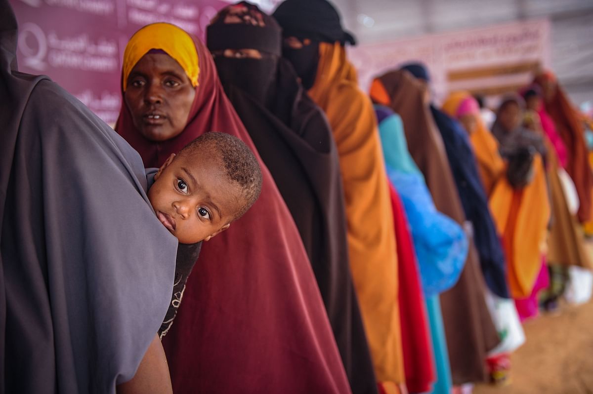 Somali internally displaced people (IDPs) wait in a line for food distribution in Mogadishu on 22 May 2018. About 800 internally displaced people from 8 camps in Mogadishu receive Iftar dinner, the first meal after the daytime fast during the month of Ramadan, at food distribution centre annually installed during Ramadan by the Qatari international NGO Qatar Charity. Photo: AFP