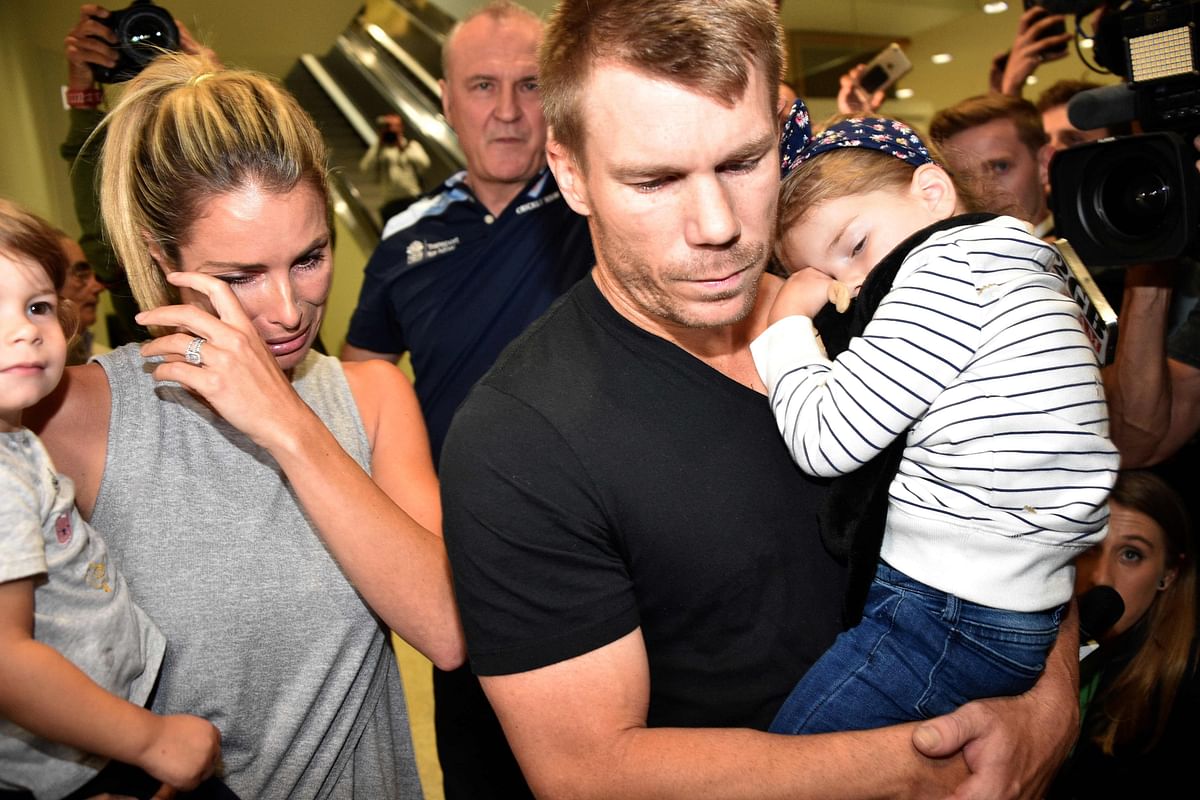 This file photo taken on March 29, 2018 shows Australian cricketer David Warner (C), his wife Candice and their daughters leaving the airport after arriving back in Sydney from South Africa. AFP